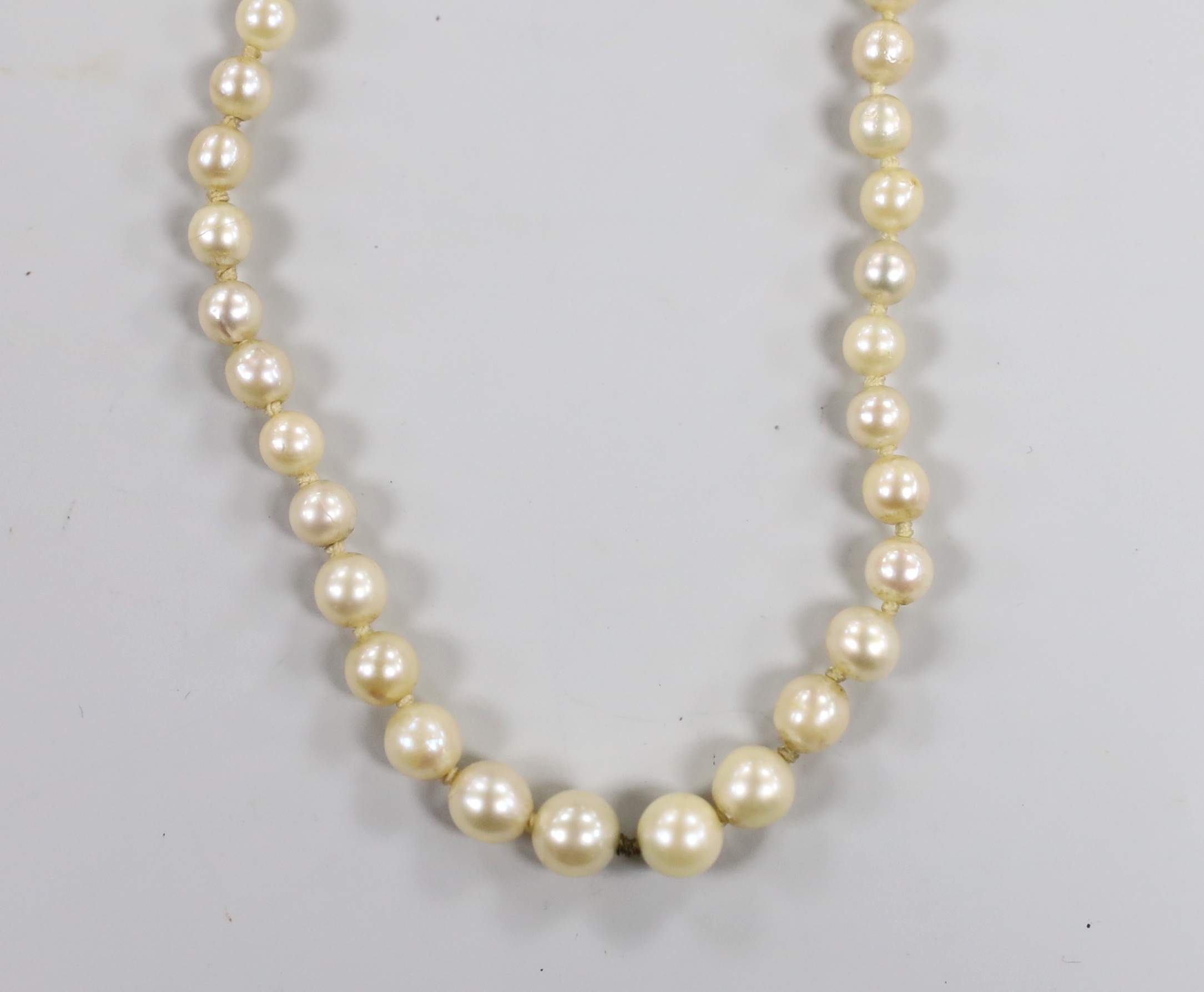 A single strand graduated cultured pearl necklace, with two stone diamond set yellow metal clasp, 37cm.